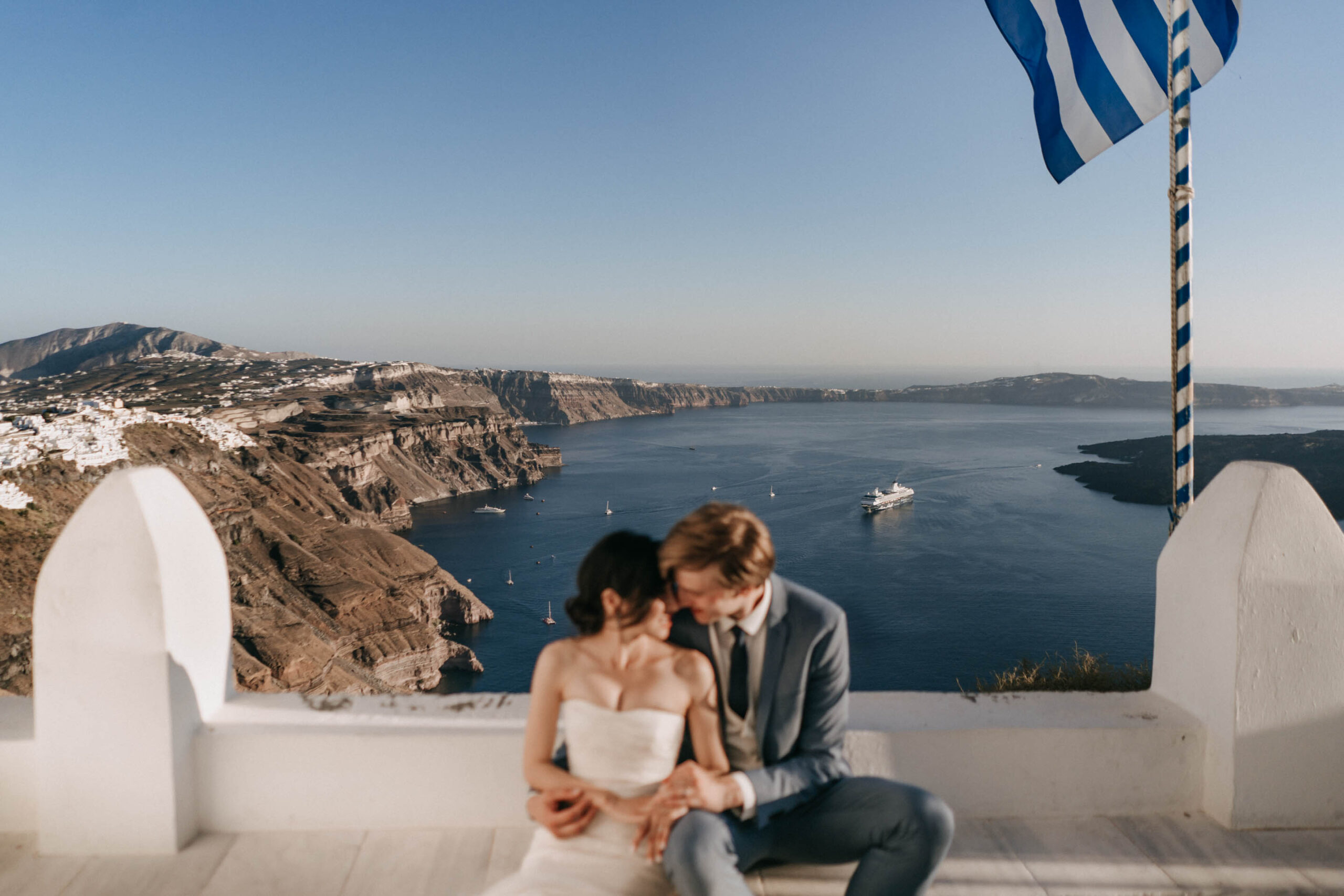 Couple in early light in a quiet Santorini caldera village before the island wakes.
